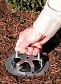 Photo of Terminix service technician placing a monitoring station in the ground.